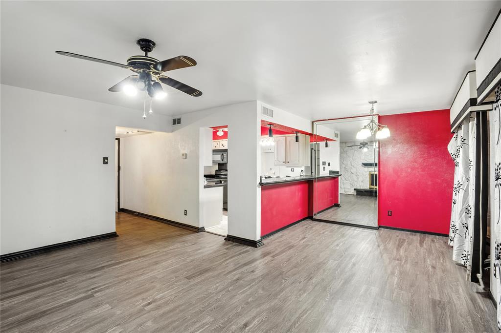 a kitchen with stainless steel appliances granite countertop a hardwood floor and chandelier