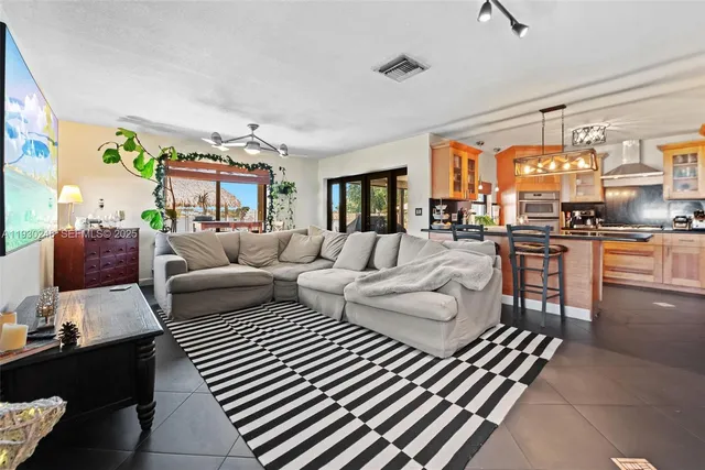 a kitchen with stainless steel appliances granite countertop a refrigerator a stove and a sink with cabinets