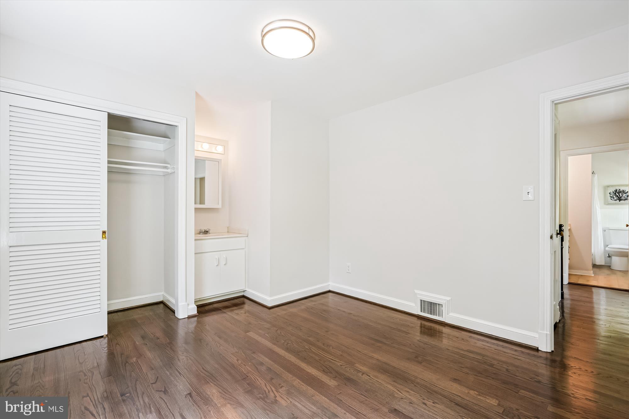 7206 Pinehurst Parkway Chevy Chase, MD 20815 - Photo 28 of 56 an empty room with wooden floor and windows