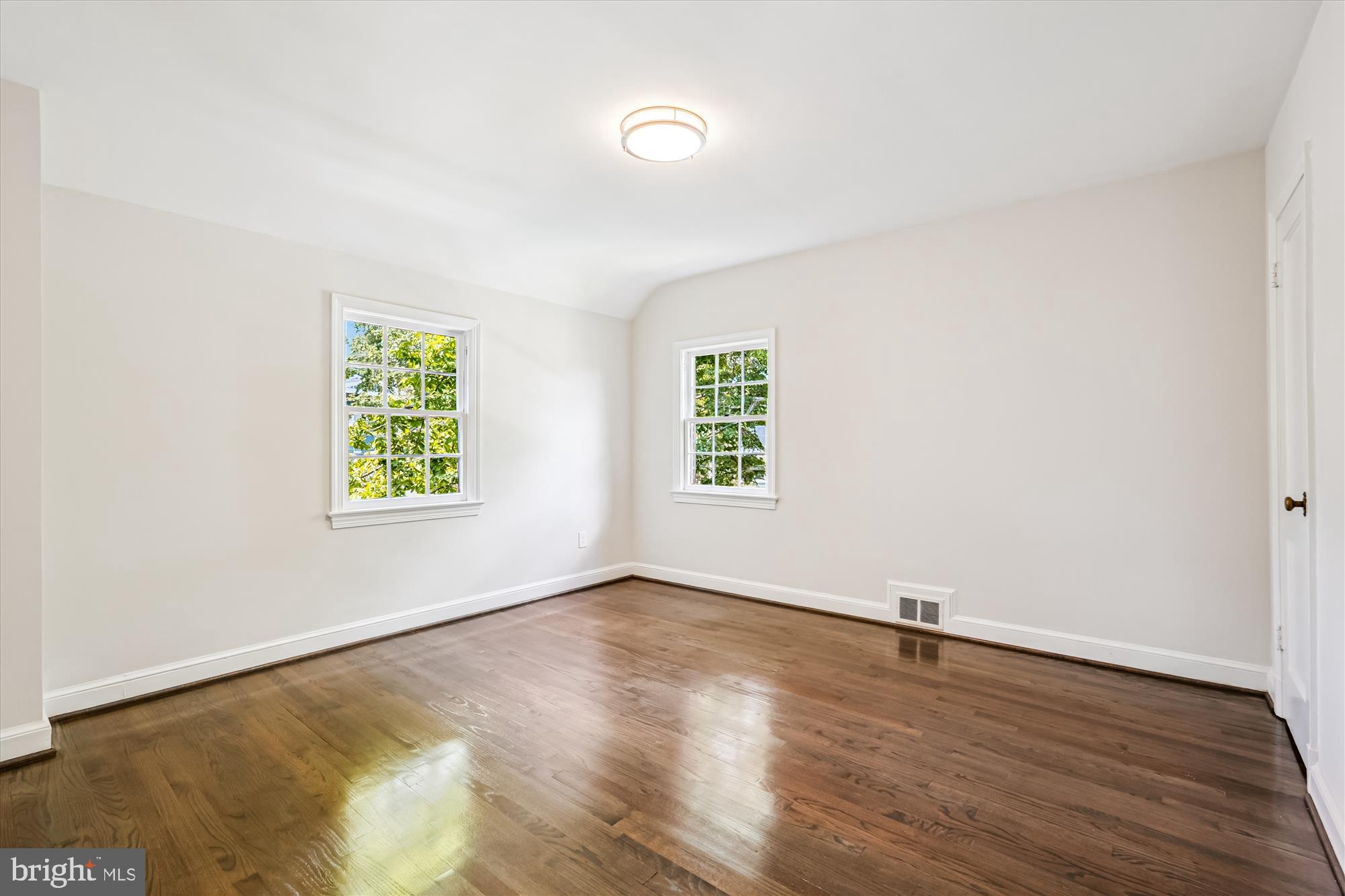 7206 Pinehurst Parkway Chevy Chase, MD 20815 - Photo 30 of 56 an empty room with wooden floor and windows