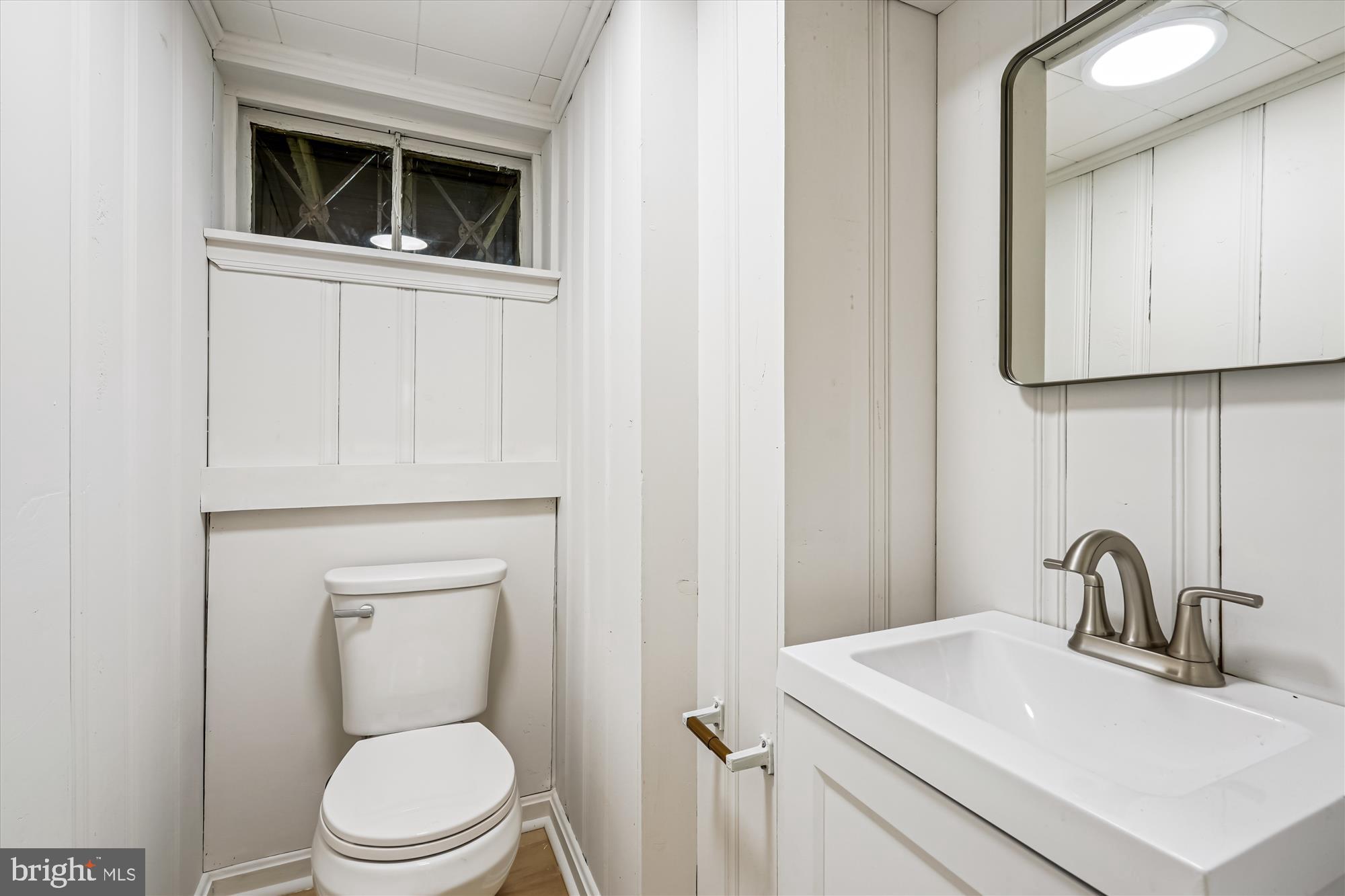 7206 Pinehurst Parkway Chevy Chase, MD 20815 - Photo 37 of 56 a bathroom with a toilet a sink and mirror