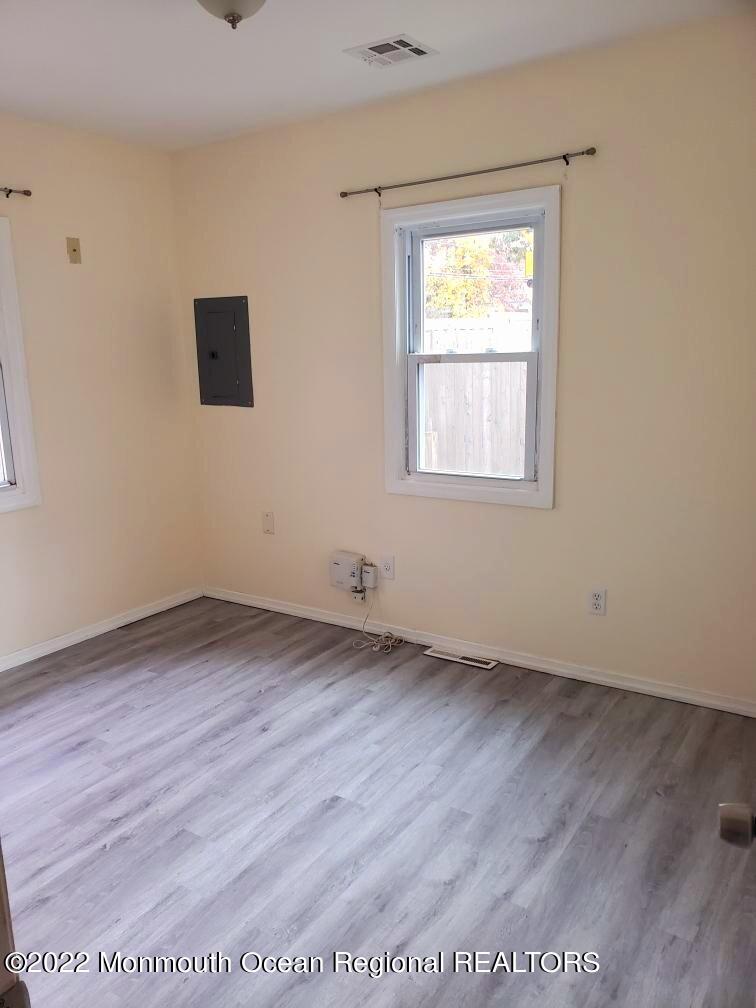 683 Mantoloking Road Brick, NJ 08723 - Photo 4 of 9 a view of an empty room with wooden floor and a window