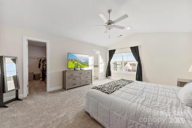 a spacious bedroom with a bed and a chandelier