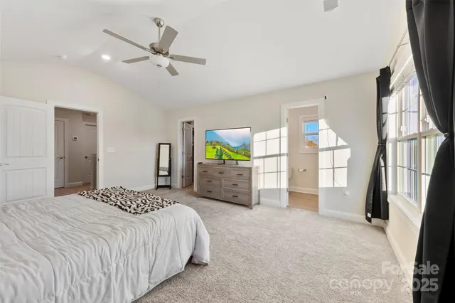 a bedroom with a bed a window and a flat screen television