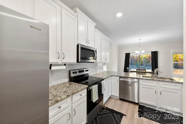 a kitchen with white cabinets and appliances