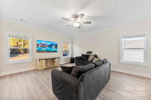 a living room with furniture a window and a flat screen tv