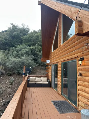 a view of a balcony with two chairs and a barbeque