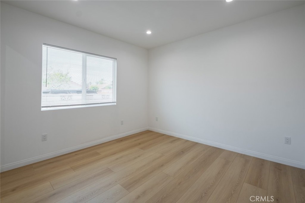 12974 Goleta Street Pacoima, CA 91331 - Photo 11 of 18 an empty room with wooden floor and windows