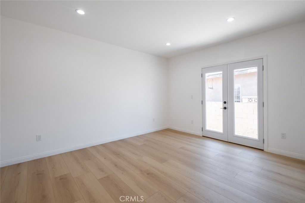 12974 Goleta Street Pacoima, CA 91331 - Photo 13 of 18 an empty room with wooden floor and mirror