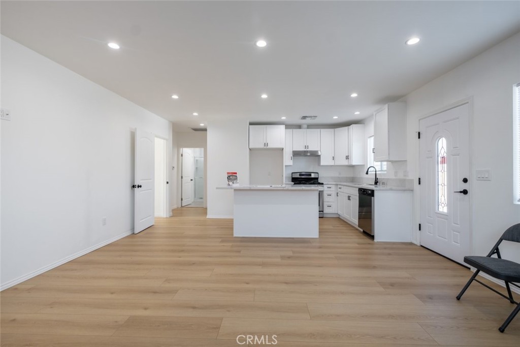 12974 Goleta Street Pacoima, CA 91331 - Photo 4 of 18 a view of kitchen with kitchen island a sink a stove a refrigerator and white cabinets