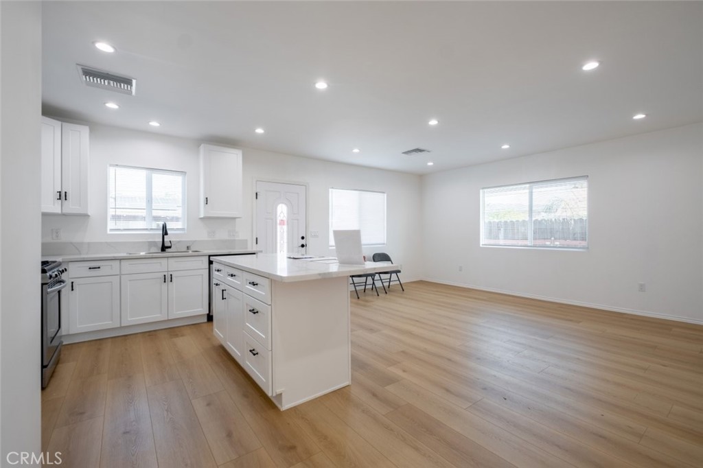 12974 Goleta Street Pacoima, CA 91331 - Photo 6 of 18 a kitchen with cabinets wooden floor and a window