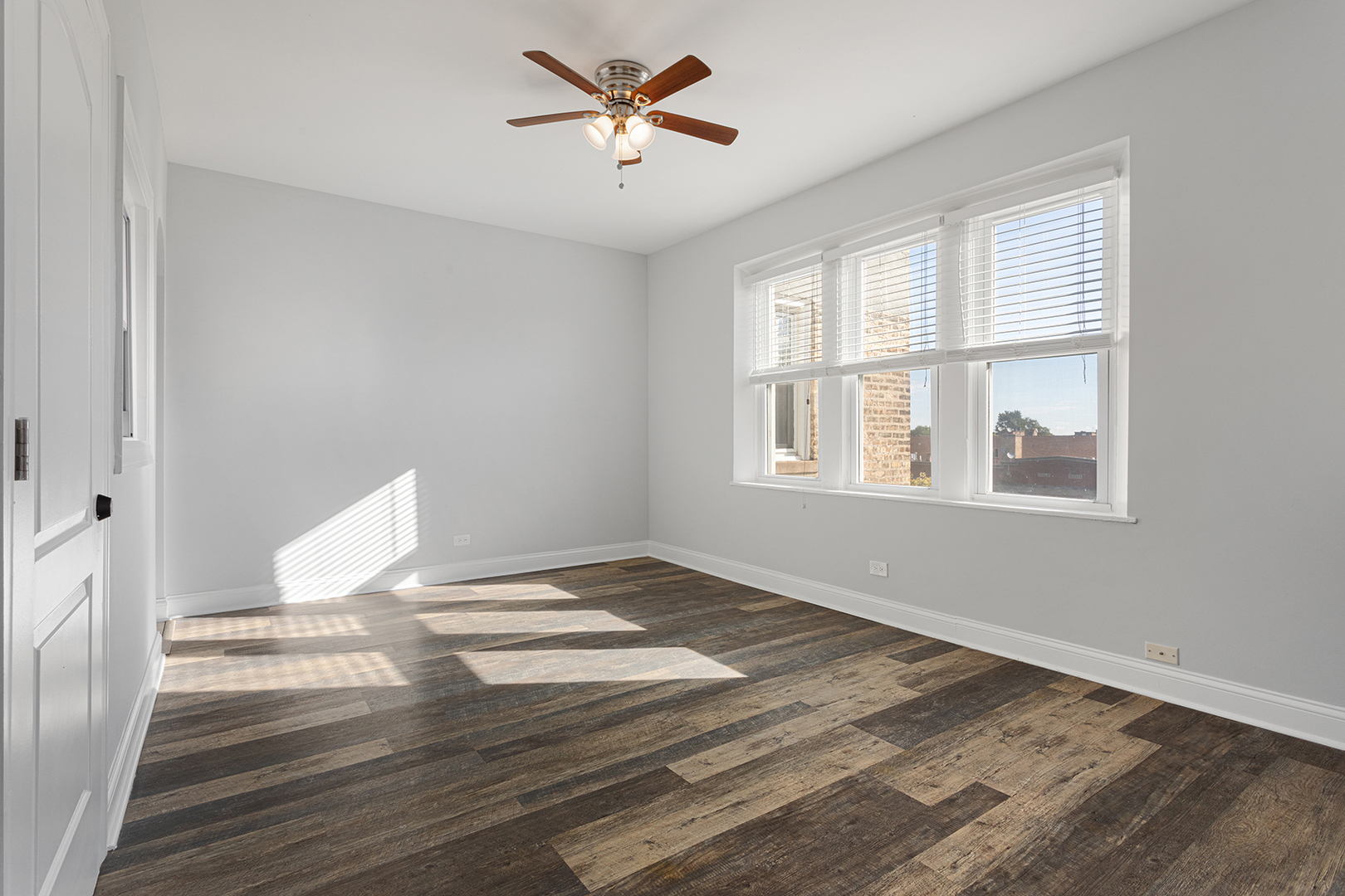 1608 West Sherwin Avenue, Unit 710 Chicago, IL 60626 - Photo 2 of 13 a view of an empty room with wooden floor and a window