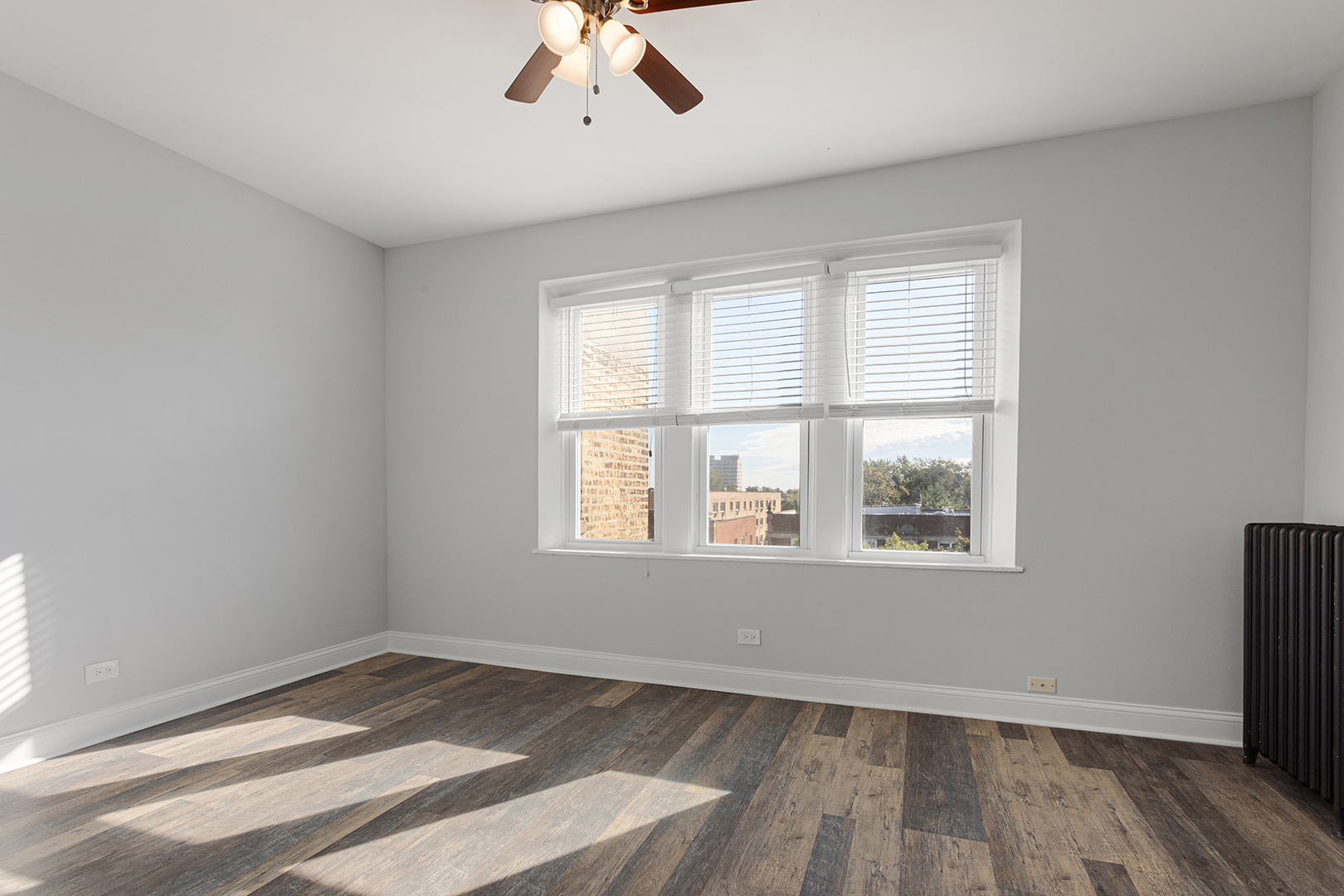 1608 West Sherwin Avenue, Unit 710 Chicago, IL 60626 - Photo 5 of 13 a view of an empty room with wooden floor and a window