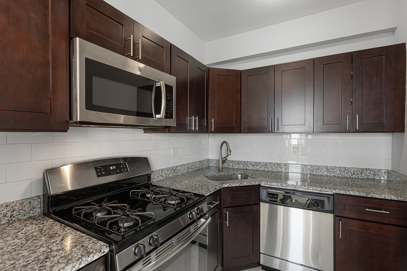 1608 West Sherwin Avenue, Unit 710 Chicago, IL 60626 - Photo 7 of 13 a kitchen with stainless steel appliances granite countertop a stove and a microwave