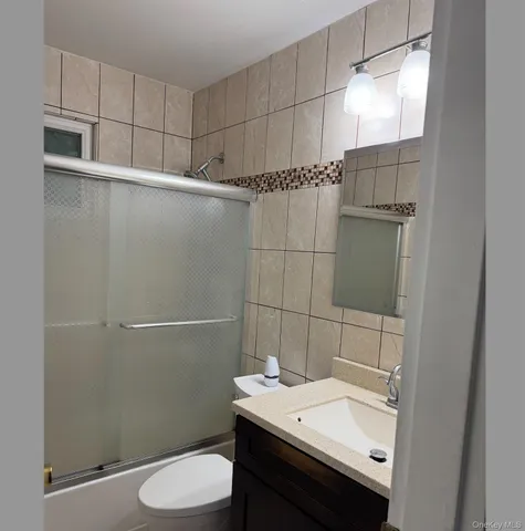 a view of an empty room with furniture and a refrigerator