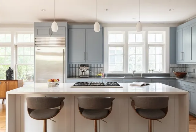a kitchen with stainless steel appliances a sink a table and chairs in it