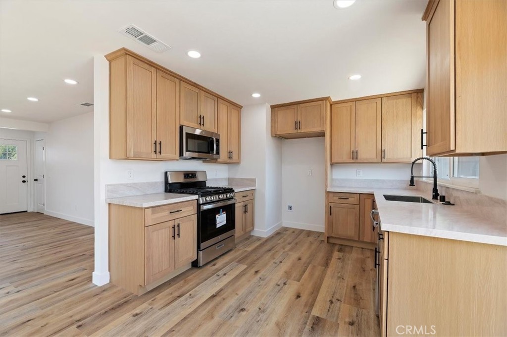 6940 Keating Drive Riverside, CA 92503 - Photo 4 of 15 a kitchen with a sink a counter top space stainless steel appliances and cabinets