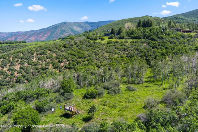 a view of a lush green hillside and a building