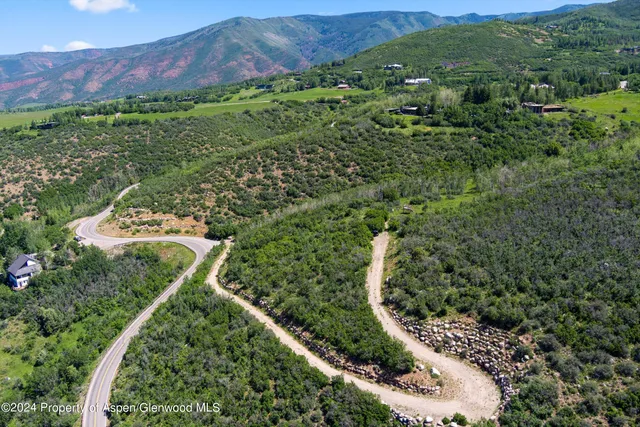 a view of a lush green hillside and houses