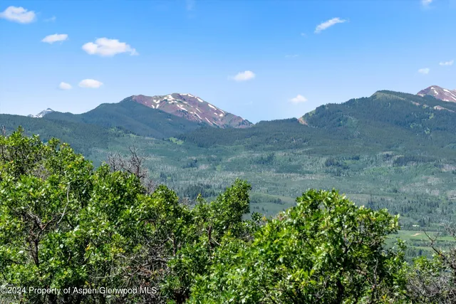 a view of a lush green hillside and a building