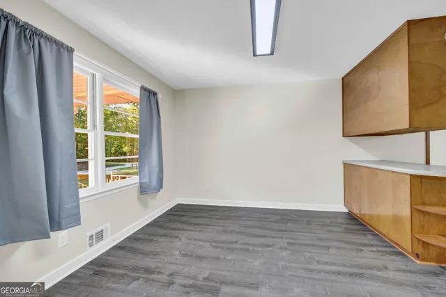 a view of a kitchen with wooden floor and electronic appliances