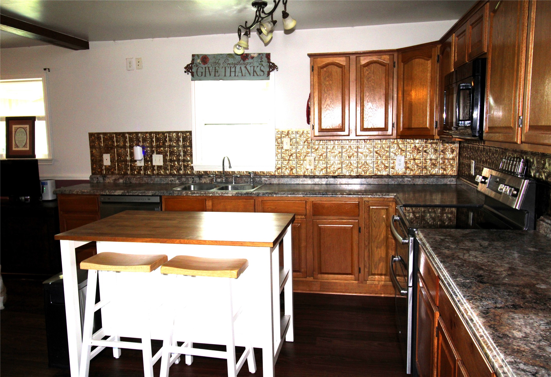 303 North 9th Street Beasley, TX 77417 - Photo 15 of 41 This kitchen includes a central island with seating, perfect for casual meals or entertaining. The natural light and modern appliances enhance its functionality and charm.