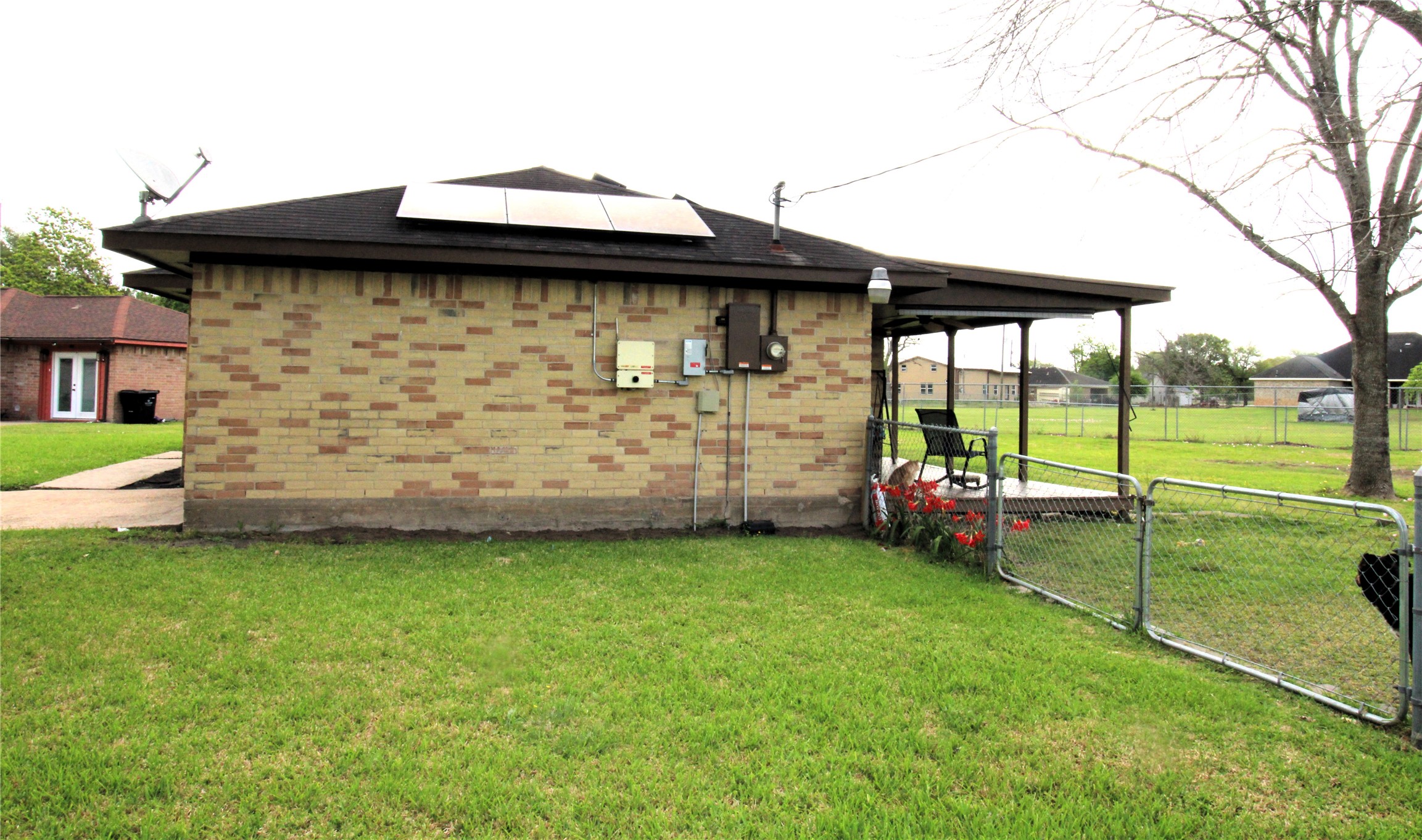 303 North 9th Street Beasley, TX 77417 - Photo 21 of 41 The photo shows the side of the single-story brick home with a covered patio area.The lot is over 15,000 sq. ft. which is spacious and open, providing ample outdoor space and privacy.