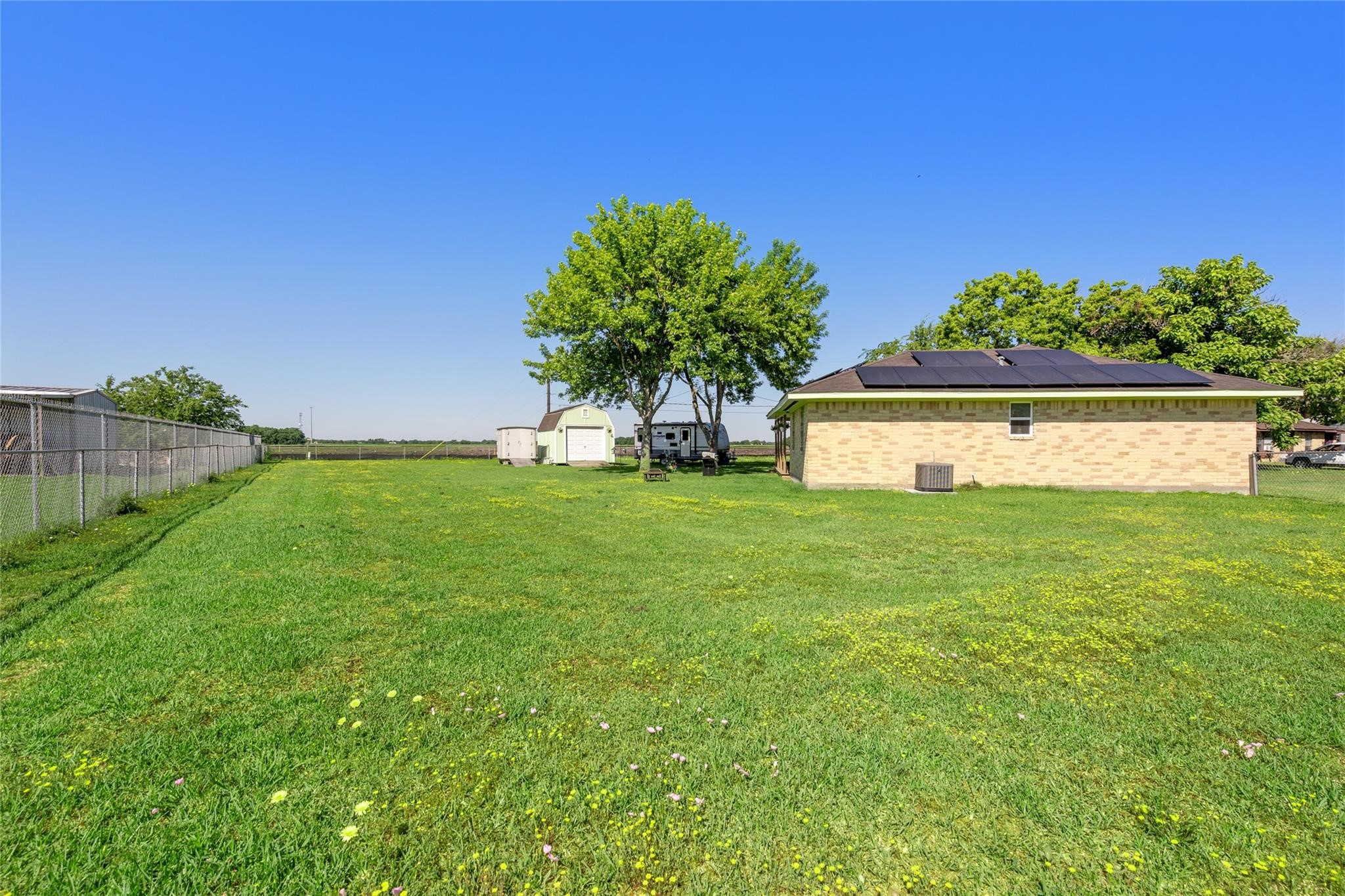 303 North 9th Street Beasley, TX 77417 - Photo 25 of 41 This view shows backyard with mature trees. It's completly fenced offering a blend of open space and functionality.