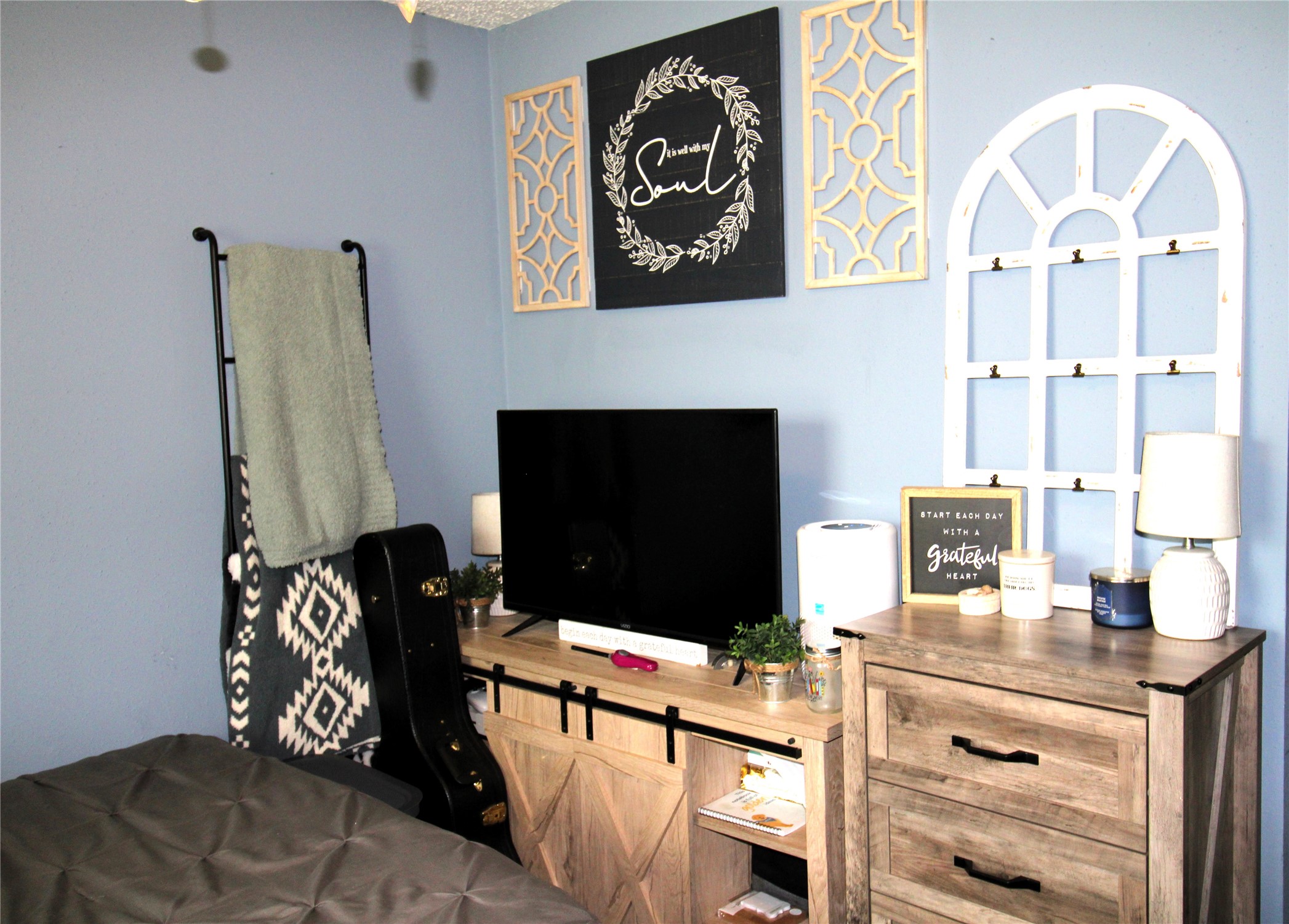 303 North 9th Street Beasley, TX 77417 - Photo 34 of 41 Bedroom with natural light features a metal bed frame, patchwork quilt, and practical shelving. Ideal for a guest room or small bedroom setup.