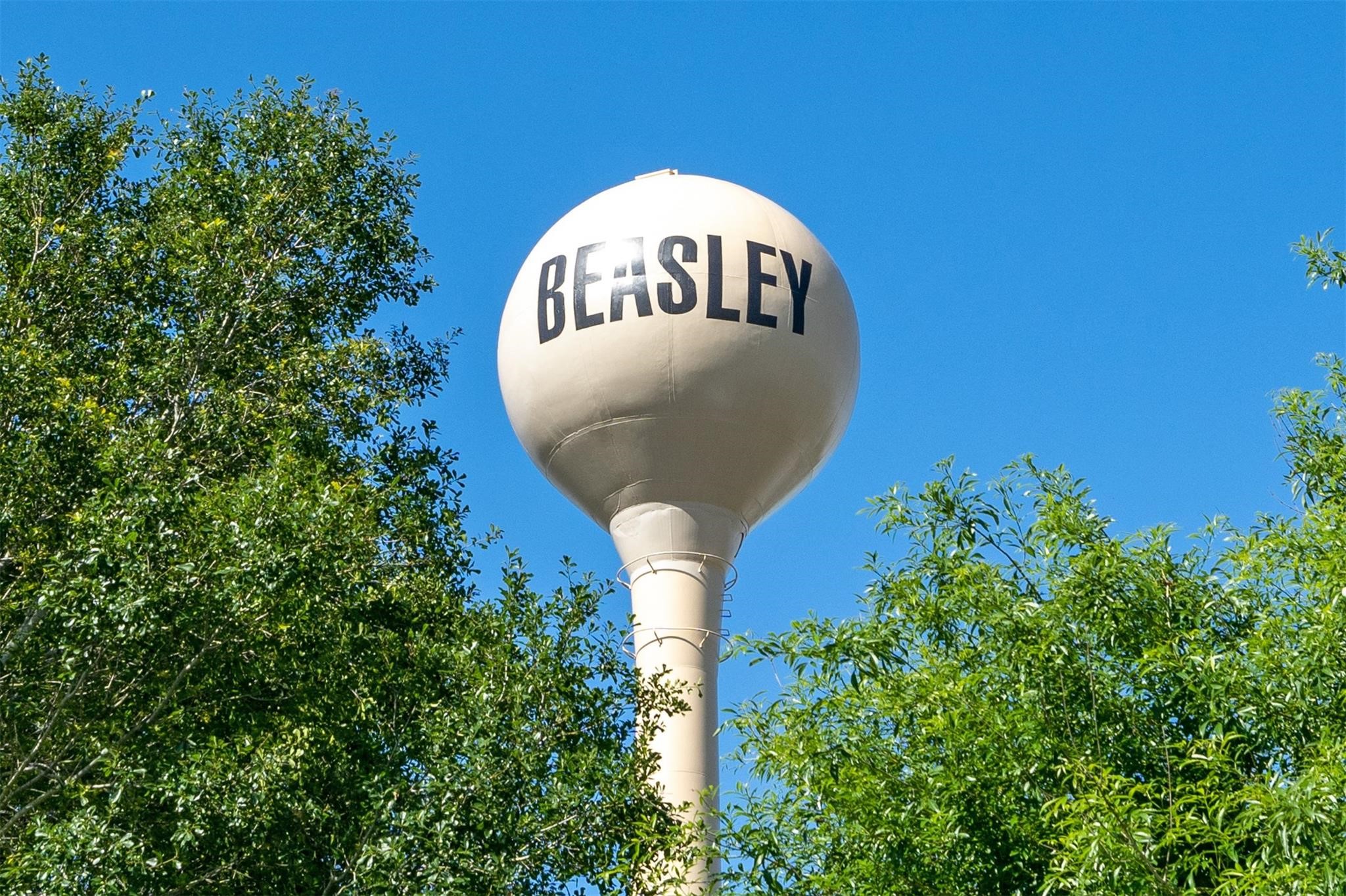 303 North 9th Street Beasley, TX 77417 - Photo 41 of 41 The photo shows a water tower labeled "Beasley," set against a clear blue sky and surrounded by leafy green trees, welcoming you to the town of Beasley! Close to city with small town feel!