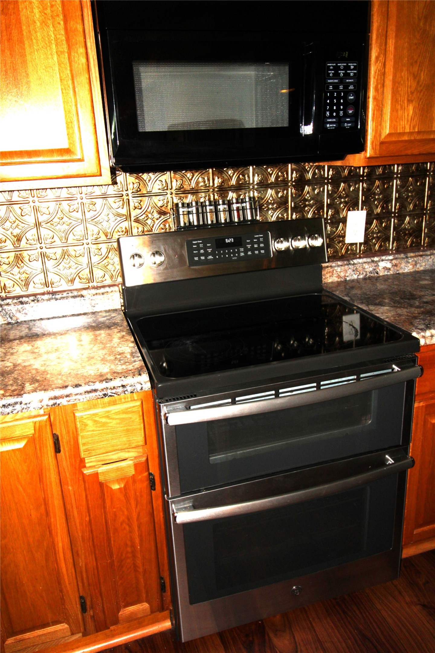 303 North 9th Street Beasley, TX 77417 - Photo 9 of 41 This kitchen features microwave, set against a decorative backsplash and a granite countertop, creating a stylish and functional cooking space.