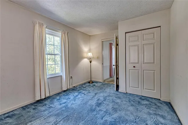 an empty room with windows and closet