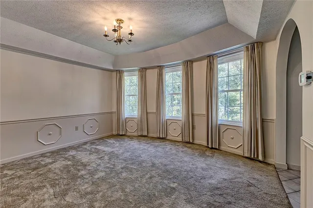 a view of an empty room with window and cabinet