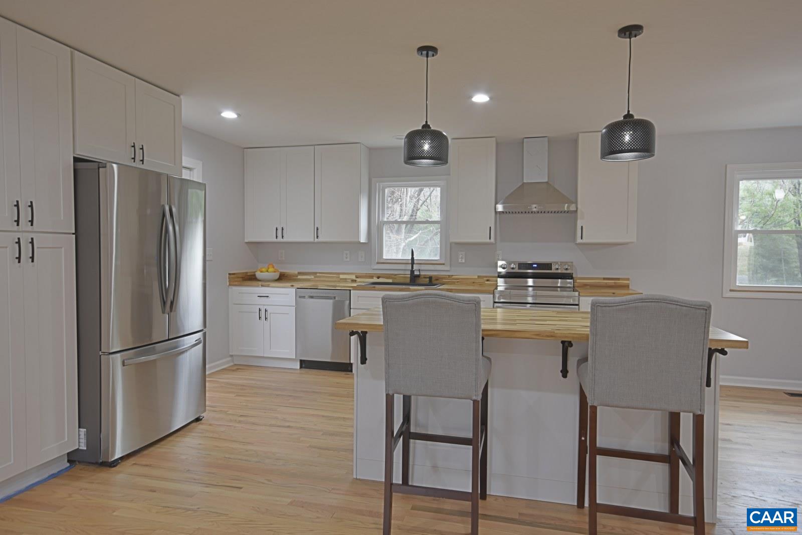 330 Brentwood Road Charlottesville, VA 22901 - Photo 5 of 26 a kitchen with granite countertop a refrigerator a sink dishwasher a stove and white cabinets with wooden floor