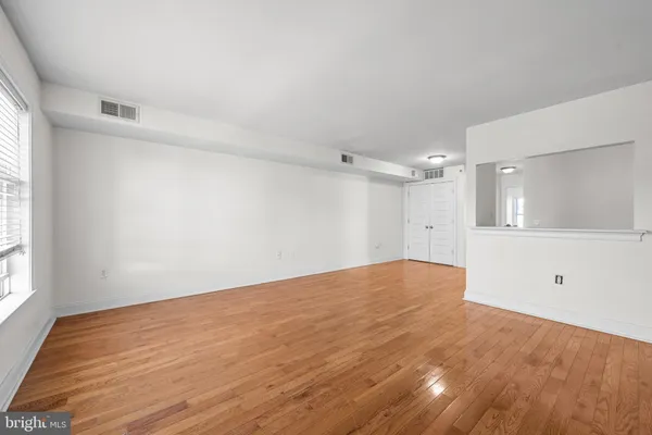a view of empty room with wooden floor