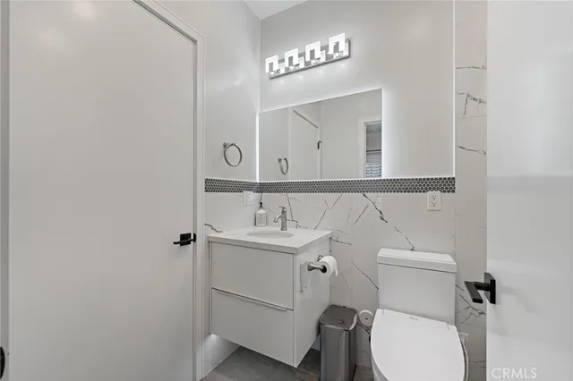 a bathroom with a toilet a sink and mirror
