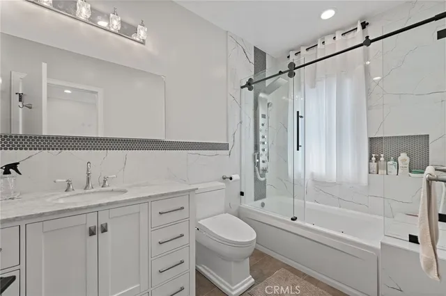 a bathroom with a sink a toilet and shower