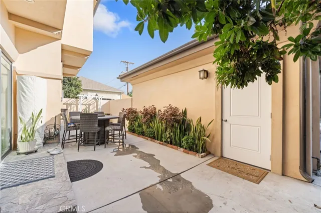 a view of balcony with table and chairs potted plants and large tree