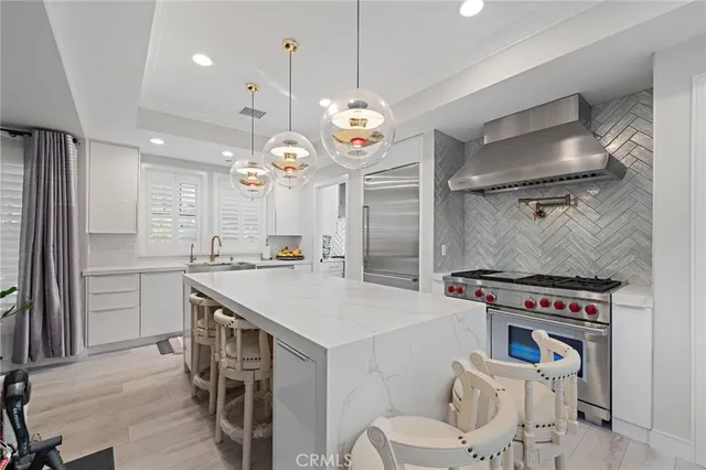 a kitchen with a stove a chandelier and a refrigerator