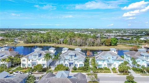 an aerial view of residential houses with outdoor space and ocean view
