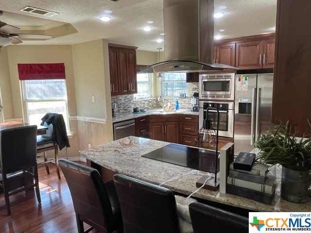 a kitchen with granite countertop a table chairs stove and refrigerator
