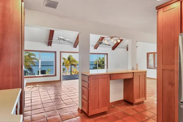 a view of a hallway with a chandelier fan and windows