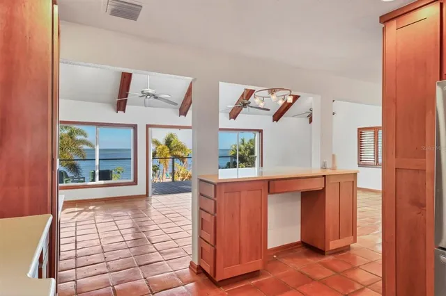 a view of a hallway with a chandelier fan and windows