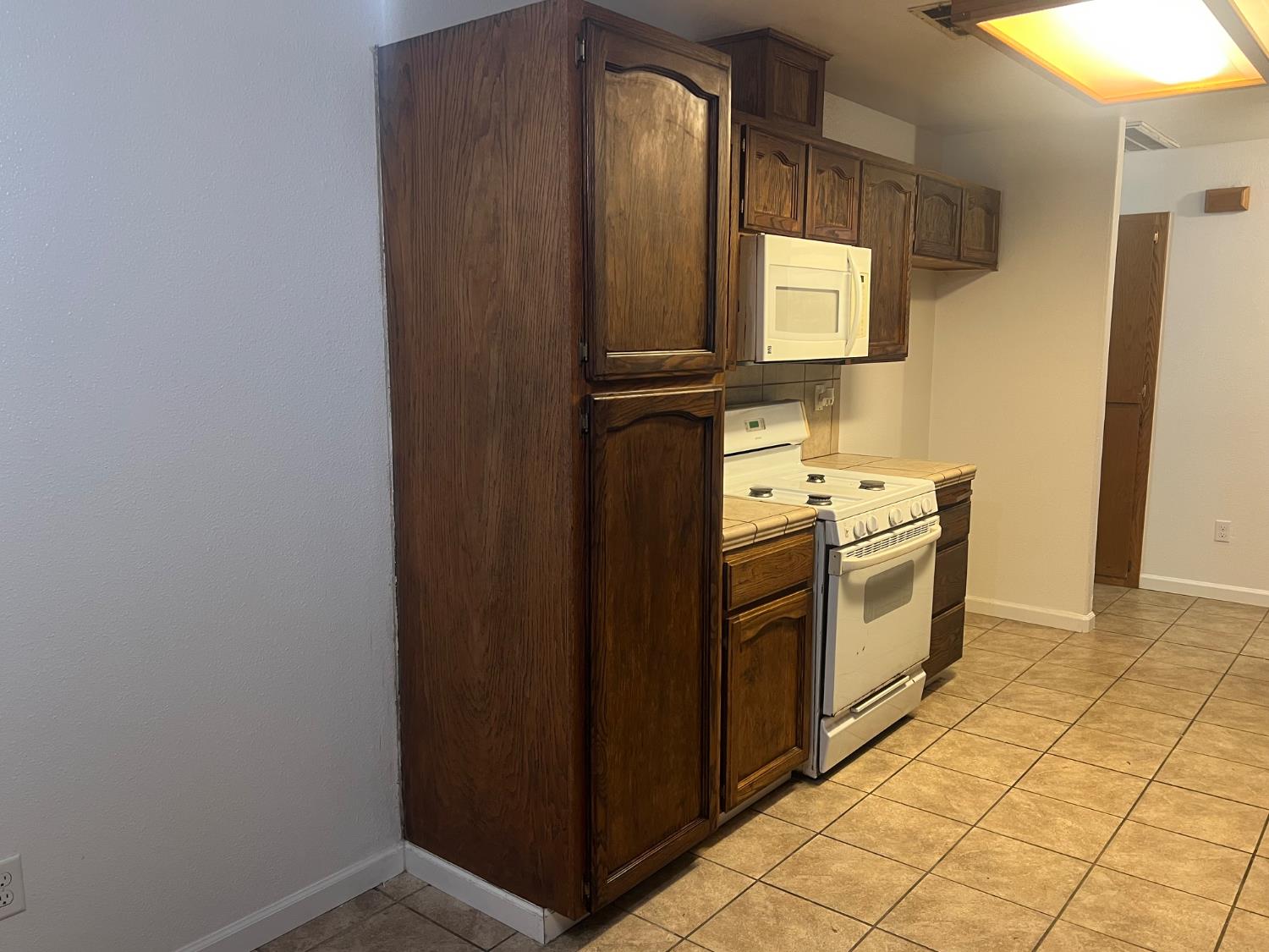 946 West Mammoth Pool Way Hanford, CA 93230 - Photo 16 of 17 a kitchen with a stove a sink and a refrigerator