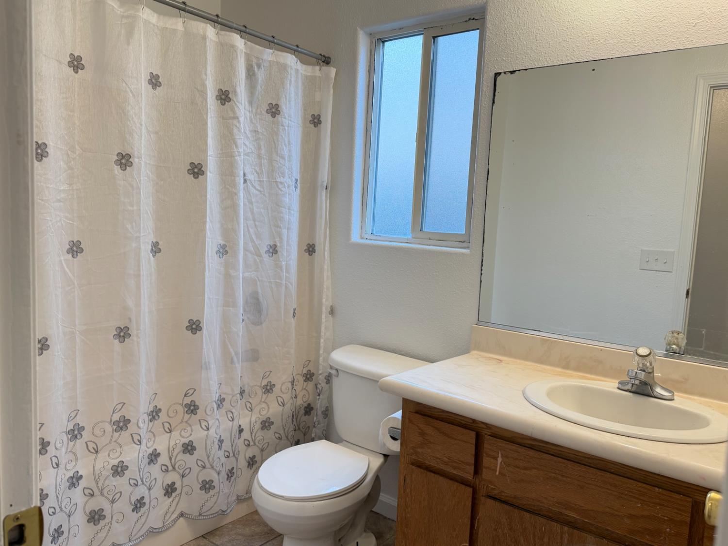 946 West Mammoth Pool Way Hanford, CA 93230 - Photo 5 of 17 a bathroom with a sink a toilet and shower curtain