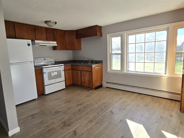 a kitchen with stainless steel appliances granite countertop a stove a sink and a refrigerator
