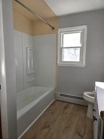 a white bath tub sitting next to a white toilet