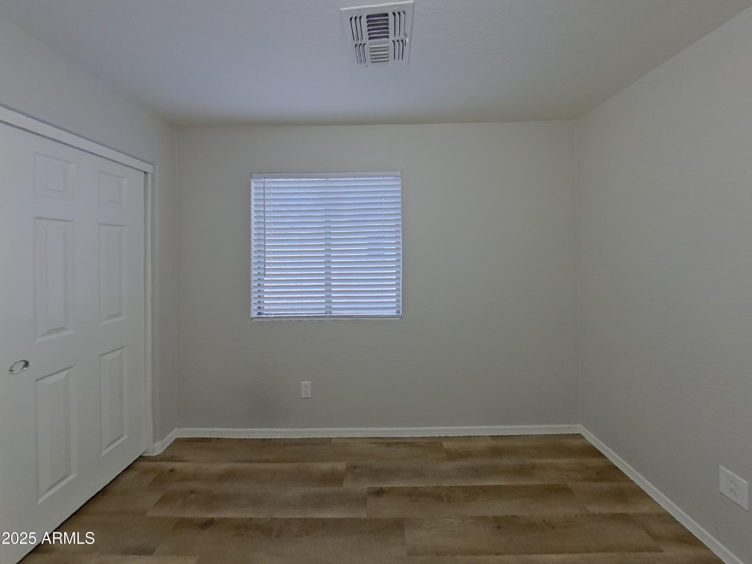19303 North Leland Road Maricopa, AZ 85138 - Photo 12 of 16 an empty room with wooden floor and windows