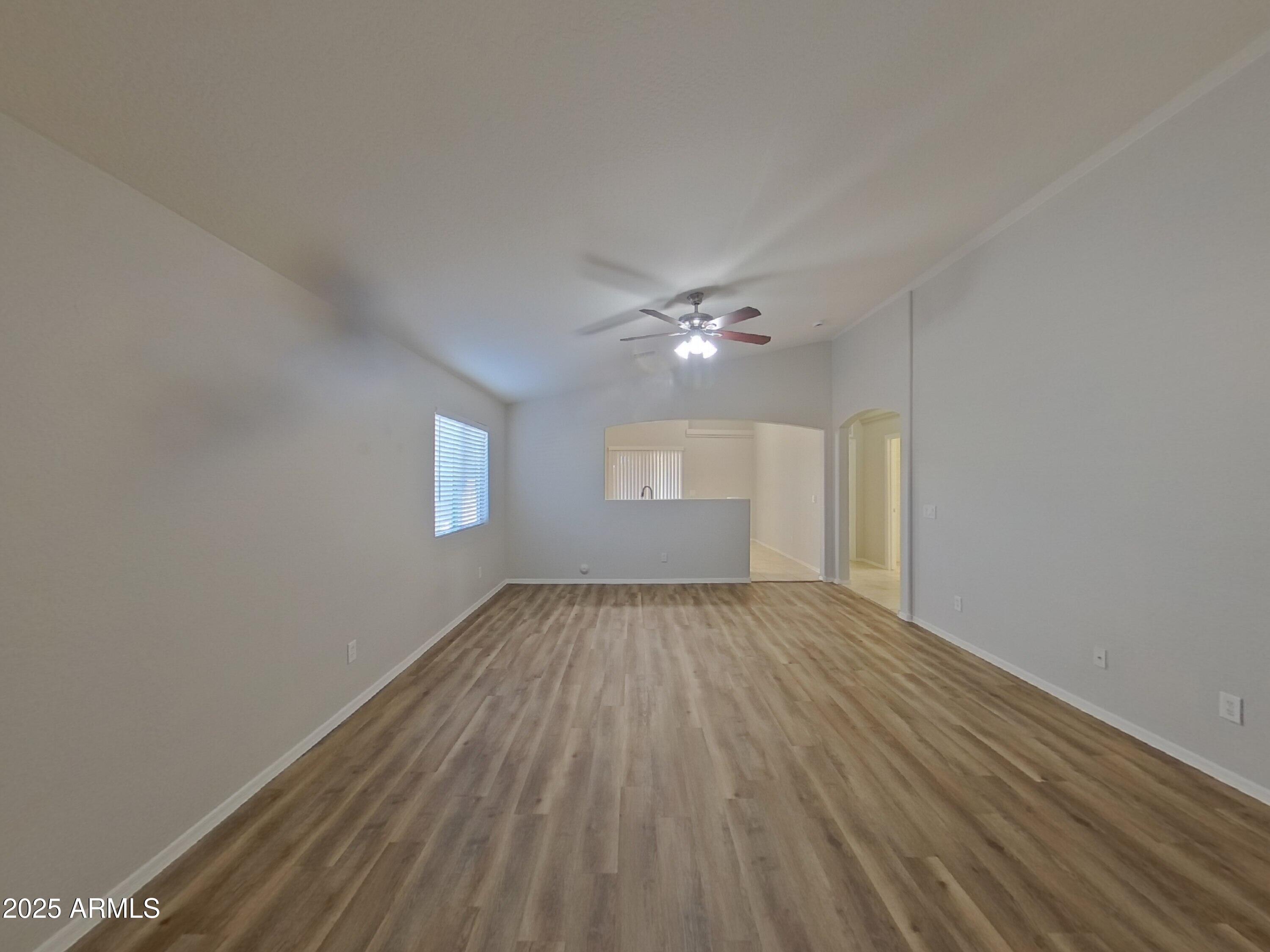 19303 North Leland Road Maricopa, AZ 85138 - Photo 2 of 16 a view of an empty room with wooden floor and window