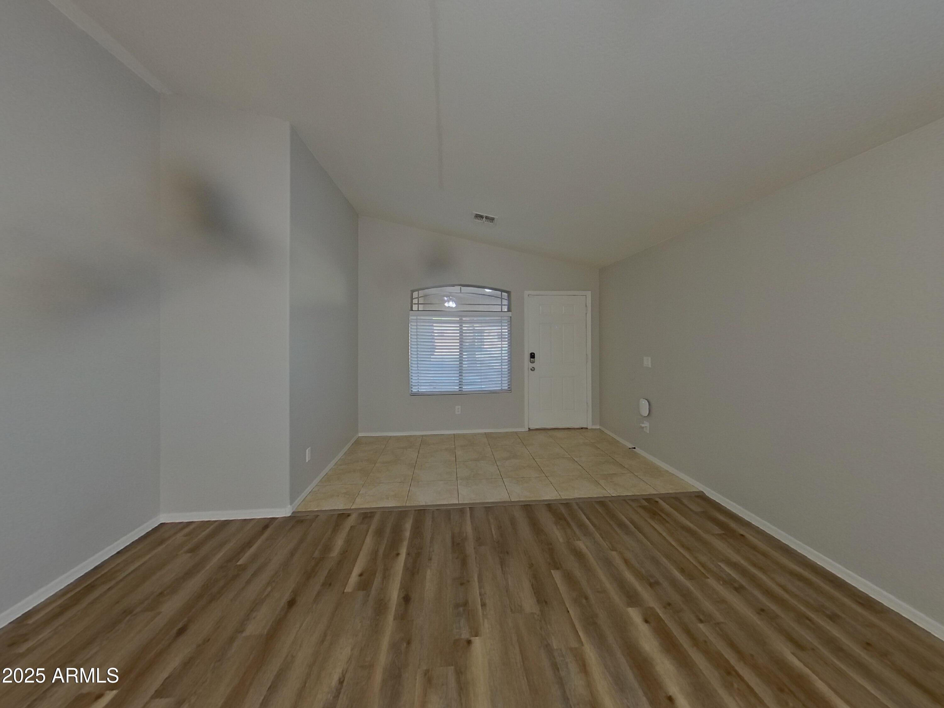 19303 North Leland Road Maricopa, AZ 85138 - Photo 3 of 16 an empty room with wooden floor and windows